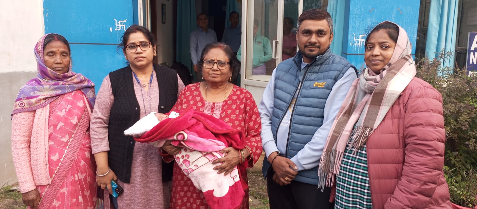 Family and staff with newborn baby